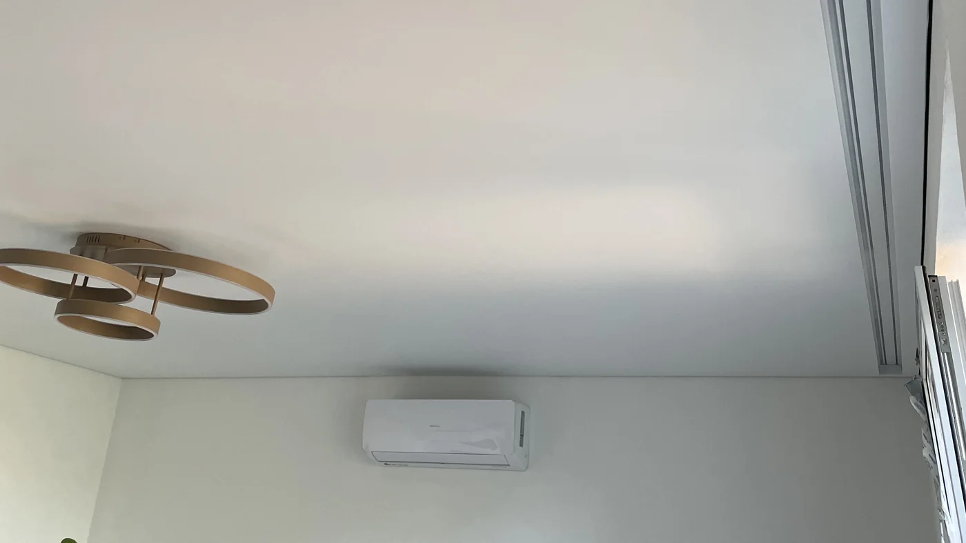 Realizacja SkyArt: biały matowy sufit napinany w pokoju z lampą sufitową