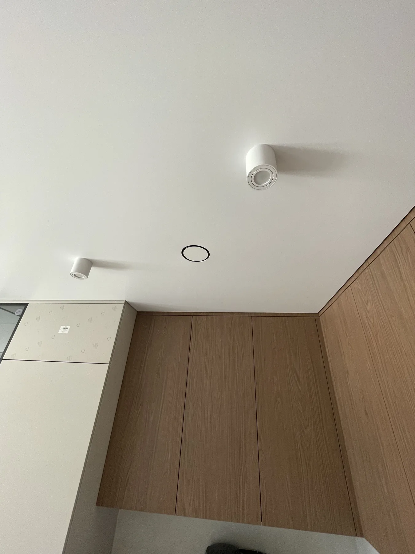 Jasny matowy sufit napinany z oprawami punktowymi w nowoczesnym wnętrzu