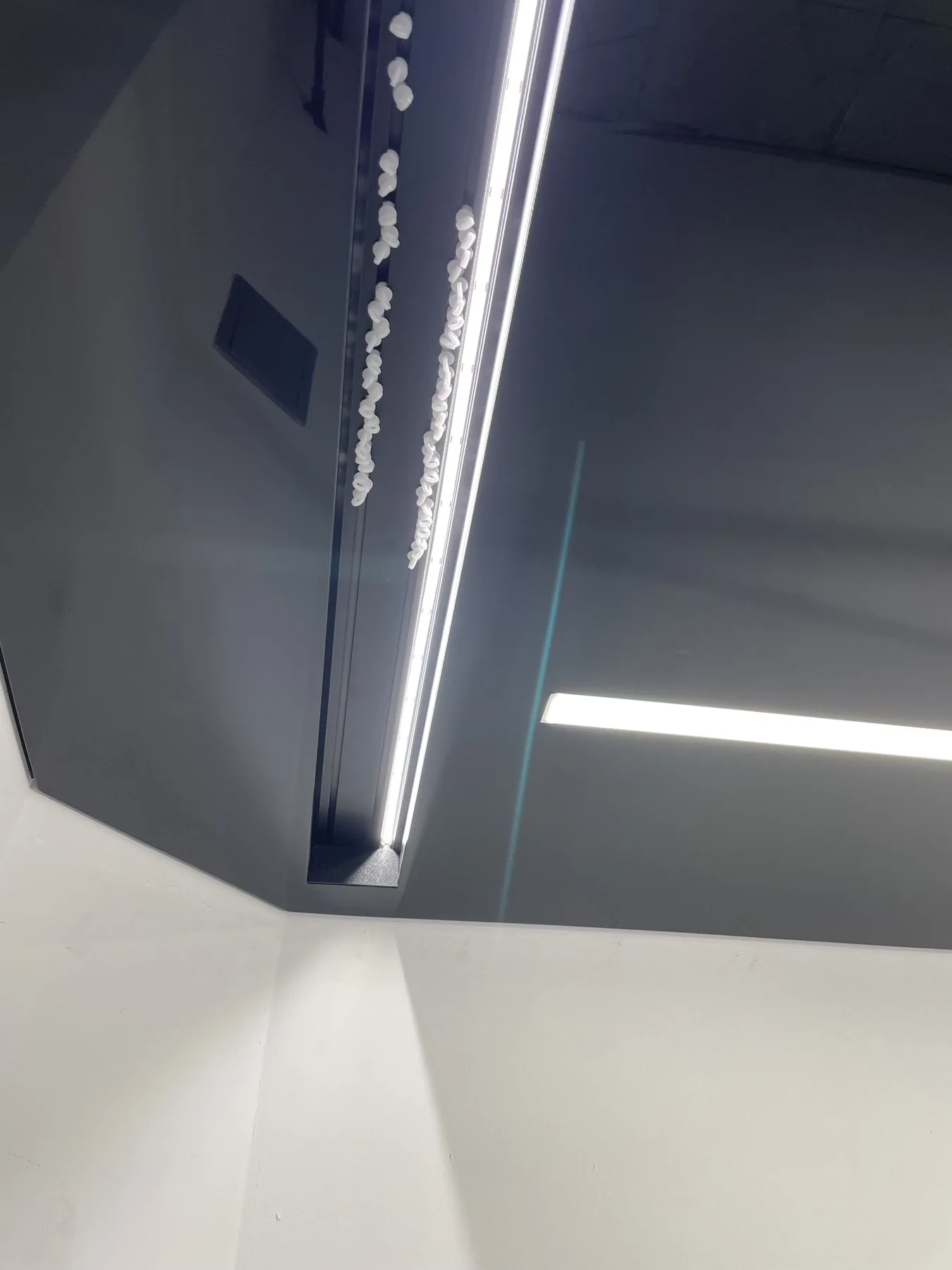 Ciemny sufit napinany z długimi liniami świetlnymi LED